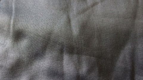 Ein Kissenbezug mit deutlichen Falten zeigt die Textur, die durch den Druck während des Schlafens entstanden ist.