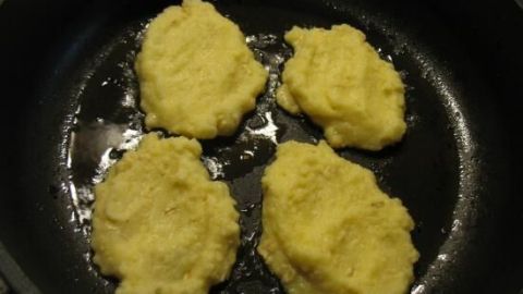 Goldbraun gebratene Quark-Puffer aus Kloßmasse liegen in einer Pfanne und werden knusprig zubereitet.