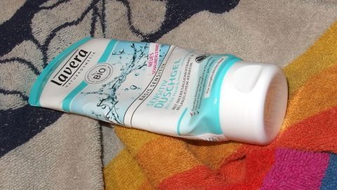 Eine Tube Duschgel liegt auf einem bunten Handtuch, bereit zur Verwendung für die Händewäsche.