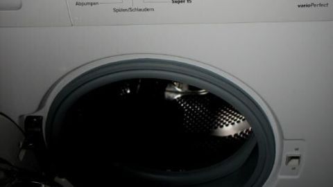 Eine Waschmaschine mit offener Tür zeigt das Innere beim Reinigungsvorgang der Gummidichtung unter Umständen im Badezimmer.