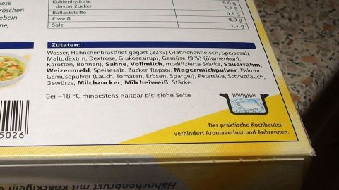 Eine Verpackung mit Nährwertangaben und Zubereitungshinweisen liegt auf einer Küchentheke, bereit zum Kochen.