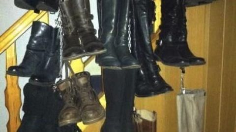 Stiefel sind an einer Treppe platzsparend aufgehängt, um Ordnung zu schaffen und den Platz effizient zu nutzen.