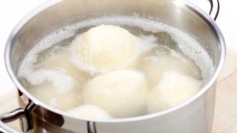 Im Topf kochen mehrere Mehlknödel in sprudelndem Wasser und bilden dabei leckere, runde Teigkugeln.