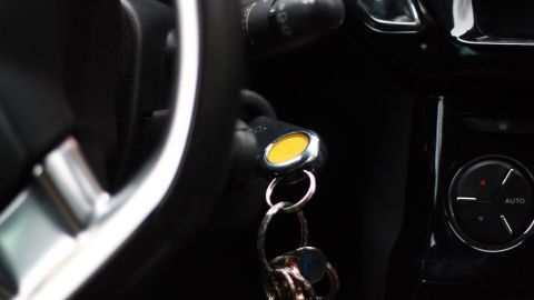 Ein schwerer Schlüsselbund hängt am Zündschloss eines Autos, was das Starten des Fahrzeugs erschwert.