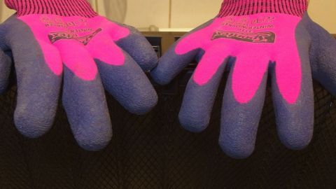 Bunte Handschuhe liegen auf einem schwarzen Untergrund, bereit zum Tragen an kalten Wintertagen für Wärme und Komfort.