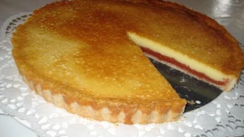 Ein runder Toggenburger Schlorzifladen liegt auf einem Servierteller, eine Stücke ist herausgeschnitten, um die Füllung zu zeigen.
