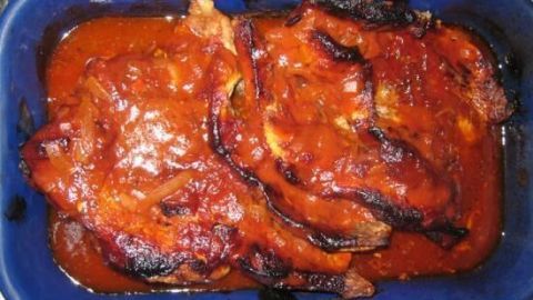 Saftige, knusprige Tomaten-Rippchen liegen in einer blauen Auflaufform, garniert mit aromatischer Soße.