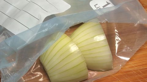 Gefrorene Zwiebeln lassen sich super in kleinste Würfelchen "zerschlagen". Zwiebeln liegen in einem durchsichtigen Beutel und sind in gleichmäßige Würfel geschnitten, bereit für die Zubereitung.