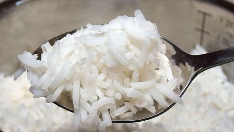 Hilfe gegen Durchfall bei Hunden: 1 Beutel Reis nur halb gar kochen, mit ein wenig (!) Futter vermischen und füttern. Weiße Reiskörner befinden sich in einem Löffel, der bereit ist, einem Hund bei Durchfall zu helfen.