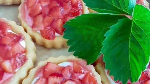 Kleine Blitztörtchen mit frischen Erdbeeren stehen auf einem Blech und warten auf den spontanen Besuch.