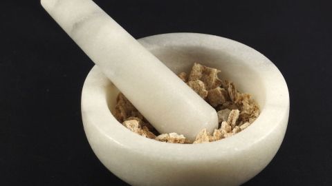 Ein Mörser aus hellem Material zerreibt Zutaten in einer Schale, um Gewürze für verschiedene Panierungen vorzubereiten.