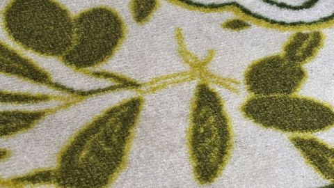 Ein Teppichboden mit einem floralem Muster wird gereinigt, um unschöne Flecken zu entfernen und seine Farbe aufzufrischen.