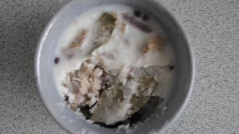 Eine Schüssel mit einer cremigen Rillette-Mischung, umgeben von einem grauen Hintergrund, lädt zum Genießen ein.