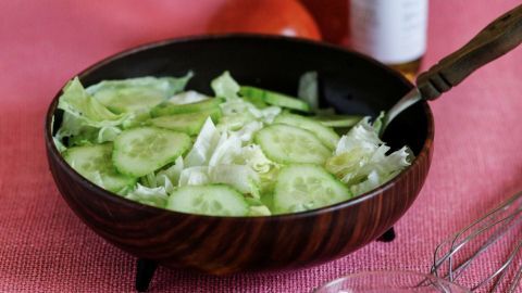 Bei Salatsaucen ist es oft der Fall, dass sich der Essig und das Öl voneinander trennen. Mit der Zugabe von etwas Natron emulgiert die Sauce besser. Eine Schüssel mit frischem Salat und Gurkenscheiben wird mit einer Salatsauce umhüllt, um emulgieren zu wirken.