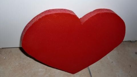 Ein rotes Herz aus Pappe liegt auf dem Boden, bereit für ein preiswertes Geschenk zum Valentinstag.