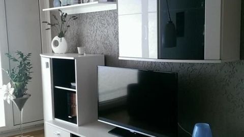 Schicke Eigentumswohnung mit modernem Wohnzimmerschrank und Fernseher, umgeben von stilvoller Dekoration und heller Atmosphäre.