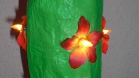 Ein leuchtender, grüner Kaktus aus Papier mit roten Blütenlampen steht in einem roten Topf. Text: EUROPE.