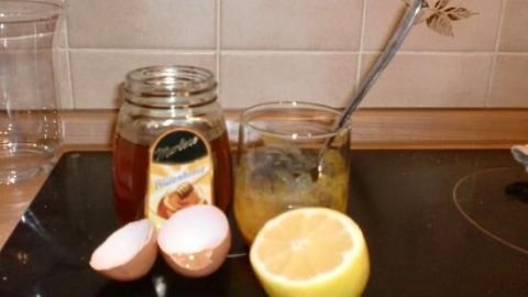 Ein Glas mit Honig und eine Schale mit einer Mischung aus Ei und Zitrone stehen auf einer Arbeitsfläche in einer Küche.