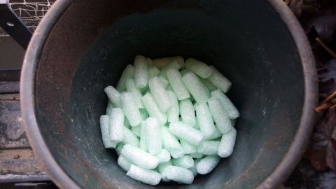 Ein Blumentopf ist mit grünen Verpackungs-Pellets gefüllt, die als leichte Drainageschicht dienen.