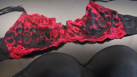 Ein eleganter BH in Schwarz und Rot liegt flach auf einer Oberfläche und zeigt Spitzendetails, die für bequemen Tragekomfort geeignet sind.
