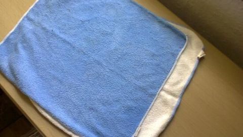 Ein blaues Microfasertuch liegt auf einem Tisch und ist bereit, „nebelfeucht“ verwendet zu werden.