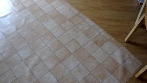 Ein großer Stoff liegt auf einem Holzboden, perfekt vorbereitet zum Zuschneiden beim Nähen.