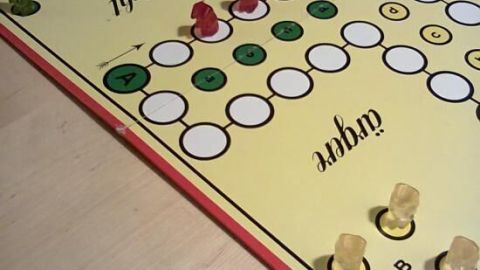 Mit kreativen Ideen kannst du Brettspiele für Kinder spannender gestalten. Schau dir die Spielbrett-Details an und finde heraus, wie du die Begeisterung beim Spielen steigern kannst. Ideal für unvergessliche Spielabende. Auf einem Brettspiel für Kinder bewegen sich grünes und rotes Spielzeug auf einem bunten Spielfeld in einem gemütlichen Raum.