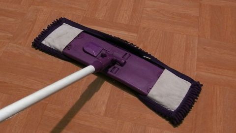 Streifenfreier Laminatboden mit Duschgel - vor allem bei neuen Böden zu empfehlen. Ein Reinigungstuch reinigt sorgfältig einen streifenfreien Laminatboden in einem hellen Raum.