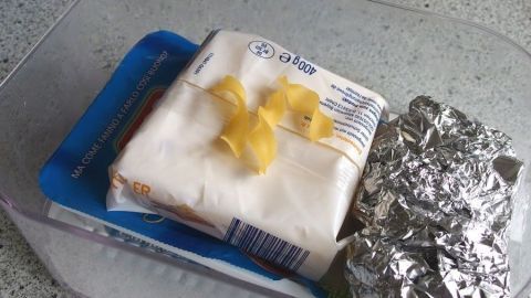 Eine Frischhaltedose enthält ein Stück Butter, Schalenreste und Aluminiumfolie, die zusammen Feuchtigkeit vermeiden sollen.