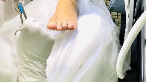 Eine Fußpflege wird durchgeführt, während die Warze behandelt wird; der Raum ist gut beleuchtet und hygienisch.