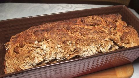 Ein frisch gebackenes Brot mit Buttermilch ruht in einer Kastenform und zeigt eine goldbraune Kruste auf einem Tisch.