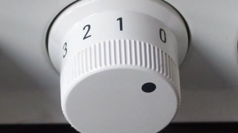 Ein weißer Drehknopf mit Zahlen von 0 bis 3 wird zur Regelung der Temperatur genutzt, um Energie zu sparen.