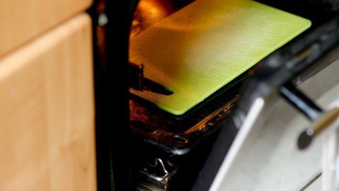 Eine gewölbte Schneidematte liegt in einem offenen Backofen, leicht erwärmt, um sie wieder glatt zu bekommen.