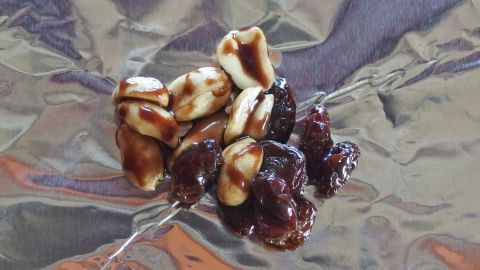 Schokorosinen liegen auf glänzendem Aluminiumfolie, während die süßen Snacks darauf warten, genossen zu werden.