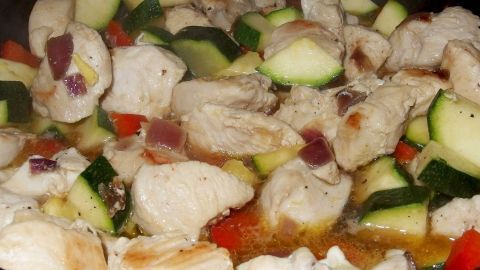 In einer Pfanne braten Stücke von zartem Fleisch zusammen mit frischen Zucchini und Paprika in einer köstlichen Mischung.