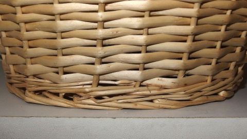Ein geflochtener Korb steht auf einem Regal, während er gegen Kratzer durch den Kontakt mit der Oberfläche schützt.