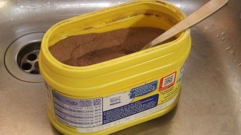 Entnahme von Lebensmitteln aus großem Aufbewahrungsgefäß, sollte man in der Spüle machen, dann bleibt die Anrichte sauber, die Spüle wird schnell abgebraust. Eine gelbe Dose mit Pulver steht in der Küche neben einem Waschbecken, einem Holzlöffel zugehörig, bereit zum Gebrauch.