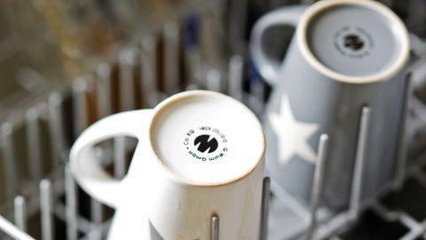 Zwei Becher mit Sternen stehen im Geschirrspüler, während das Gerät läuft, um Gerüche zu binden und Geschirr zu reinigen.