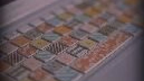 Eine bunte Tastatur steht auf einem Tisch; Tasten sind individuell gestaltet mit Pastellfarben und Mustern im Fokus auf Design.