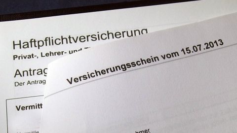 Ein Dokument mit dem Titel „Haftpflichtversicherung“ liegt auf einem Tisch. Es beschreibt den Antrag und enthält das Datum eines Versicherungsscheins.