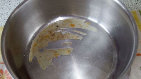 Eingebranntes in Töpfen und Pfannen entfernen mit Essig. Ein glänzender Edelstahl-Topf mit eingebrannten Rückständen zeigt, dass Essig als Reinigungslösung genutzt werden kann.