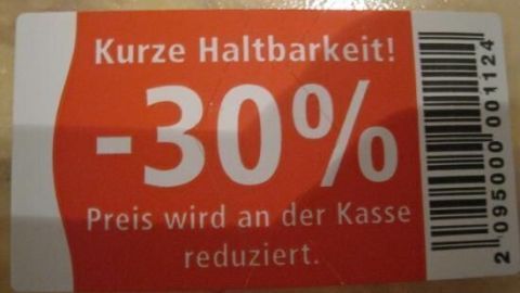 Auf einem roten Etikett steht: "Kurze Haltbarkeit! -30% Preis wird an der Kasse reduziert." mit einem Barcode rechts.