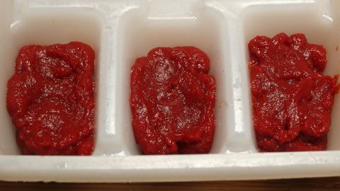 Eiswürfel aus Tomatenmark in einer transparenten Form, bereit zur Verwendung in Gerichten oder Getränken.