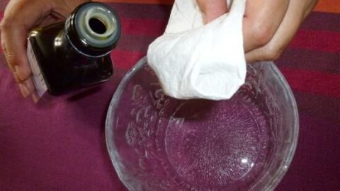 Eine Hand hält eine Flasche über einer Schüssel, während eine andere Hand ein Tuch in die Schüssel eintaucht, um Gelee zu lösen.
