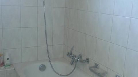 Eine Badewanne steht im Badezimmer, bereit zum Reinigen mit Waschpulver, um Fliesen und Armaturen aufzufrischen.