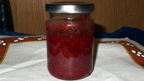Ein Glas Marmelade steht auf einer Tischdecke, bereit zum praktischen Einfüllen mit Waschlappen in der Küche.
