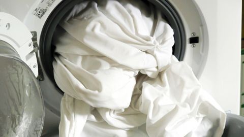 Eine große Menge weißer Wäsche hängt aus einer Waschmaschine und wird darin gewaschen, um superweiße Wäsche zu erzielen.