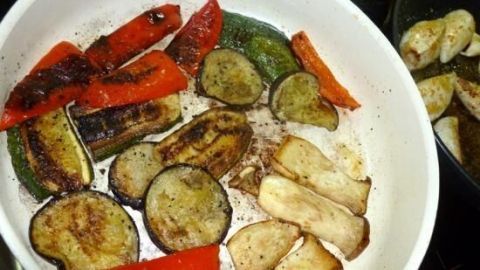 Gebratene Gemüse, darunter Paprika und Zucchini, liegen in einer Pfanne und zeigen eine appetitliche goldbraune Farbe.