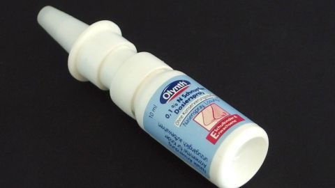 Ein Nasenspray liegt auf einem schwarzen Untergrund, bereit zur Anwendung gegen Nasenproblemen.