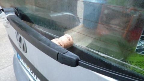 Ein Scheibenwischer auf einer Autoscheibe wird mit einem Weinkorken abgestützt, um das Festfrieren zu verhindern.